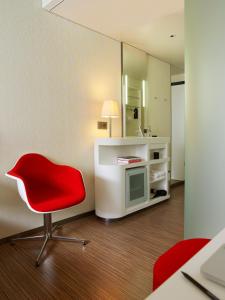伦敦伦敦泰晤士河畔世民酒店的一间设有红色椅子和镜子的房间