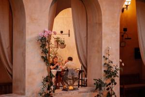 圣安那托利亚迪纳Ex Convento Santa Croce-Country resort的两个人坐在大楼的桌子上