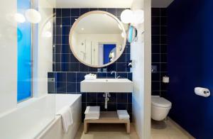 罗克布吕讷-卡普马丹维多利亚酒店的带浴缸、水槽和镜子的浴室