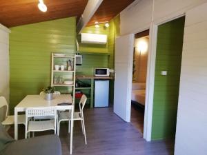 BigastroCamping la Pedrera的一间拥有绿色墙壁和桌椅的用餐室