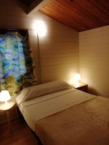 BigastroCamping la Pedrera的一间卧室设有两张床和两张台灯。