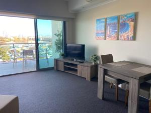 曼哲拉Dolphin View 404的客厅配有桌子、电视和桌椅