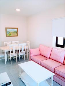 圣玛丽亚港拉尔70号公寓的客厅配有粉红色的沙发和桌子