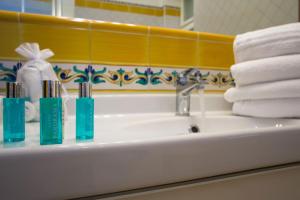 马奥莱马约里假日公寓的浴室水槽配有3个牙刷和毛巾