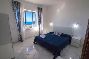 马奥莱马约里假日公寓的一间卧室设有一张床和一个海景窗户