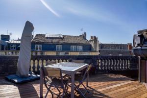 波尔多Chateau Trompette - Appartement 4 chambres avec 2 salles de bain et grande terrasse的阳台享有建筑景致,配有桌椅。