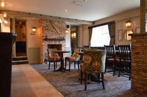 KilburnThe Forresters Arms Kilburn的一间带桌椅和壁炉的用餐室