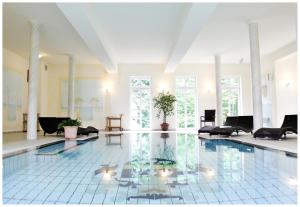 Schorssow萨伊施劳斯邵索酒店的一个带桌椅的房间的大型游泳池