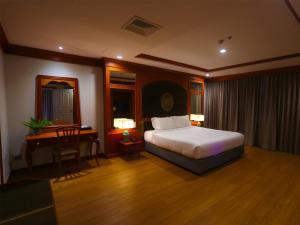 那空拍侬府Fortune River View Hotel Nakhon Phanom的一间卧室配有一张床和一张书桌