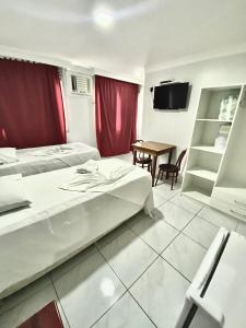 维多利亚Hotel Sol e Mar的酒店客房设有两张床和一张桌子。