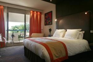 尼姆瓦岱勒酒店和Spa的一间带大床的卧室和一个阳台