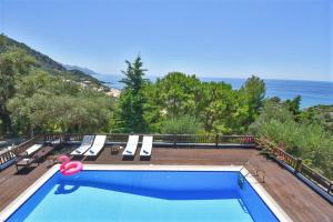 派莱卡斯Corfu Resorts Apartments的一个带椅子的游泳池,背景是大海