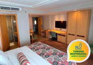 巴西利亚Lets Idea Brasília Hotel的酒店客房配有一张床、一张书桌和一台电视。