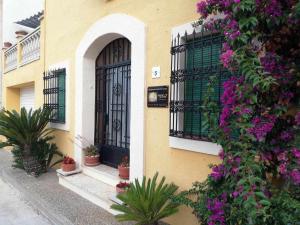 La GuardiolaJoanet Guarda turismo familiar en plena naturaleza的黄色的建筑,有黑色的门和紫色的花