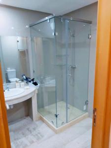 马拉喀什Luxueux appartement entre Gueliz et l'Hivernage avec WIFI的一间带玻璃淋浴和水槽的浴室