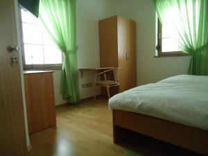 波斯托伊纳利比扎马洛奇旅馆的一间卧室配有一张床、一张书桌和一个窗户。