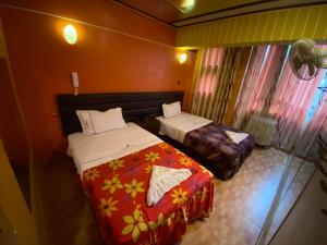 利马Hotel Manantial No,001的一间卧室设有两张床,窗户配有窗帘