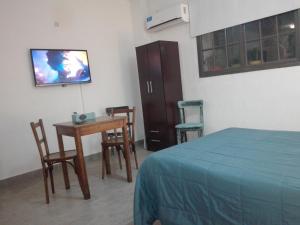 布兰卡港MONOambienteporDIA的一间卧室配有一张床、一张桌子和一台电视。