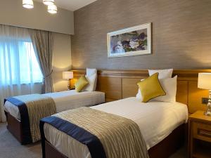 Burt安格里兰酒店的酒店客房 - 带两张带黄色枕头的床