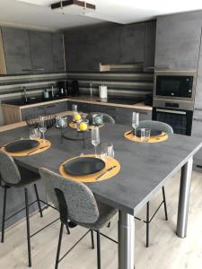 马尔梅迪NGI Vacances的厨房配有带四把椅子的大桌子和一张桌子。