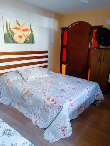 阿拉亚尔-杜卡布Suites Oliveira的一间卧室配有一张床铺,床上有毯子