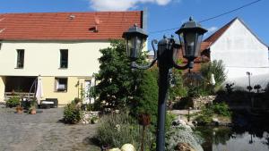 GroßbrembachPension und Gästehaus Paffrath的房屋前的街道灯和河流前的街道灯