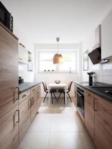萨尔布吕肯Charming LOUISE的厨房配有木制橱柜和桌子。