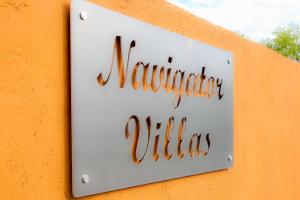 阿查拉维Navigator Villas - Houses的墙上的标志,上面写着纪念村的字条