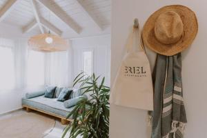雷夫卡达镇ERIEL Boutique Apartments的一间配有沙发的房间和墙上的一顶帽子