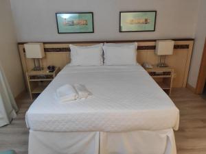 巴西利亚Apart Hotel - Esplanada dos Ministérios - Centro de Brasília的一间卧室配有一张带两盏灯的大型白色床。