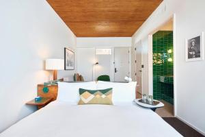 奥斯汀Hotel Magdalena的卧室配有白色的床和绿色的墙壁