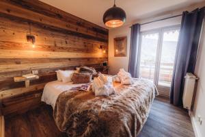 沃雅尼Chalet La Perle de L'Oisans - Appartements d'Exception的一间卧室配有一张木墙床