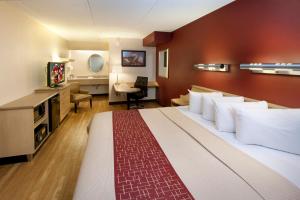 哈里斯堡Red Roof Inn Harrisburg - Hershey的酒店客房设有一张大床和一张书桌。