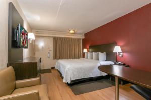 都柏林哥伦布-都柏林红屋顶PLUS+汽车旅馆的配有一张床和一张书桌的酒店客房