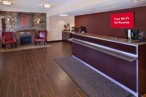 迪尔菲尔德Red Roof Inn PLUS+ Chicago - Northbrook/Deerfield的酒店大堂的酒吧,配有红色椅子
