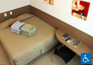 圣保罗头等酒店的一张小床,位于带桌子的房间