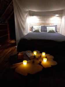 瓜皮莱斯Poponé Farm & Lodge的卧室配有一张带蜡烛的床铺,位于地板上