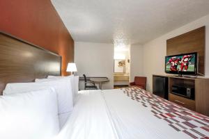 埃奇伍德埃奇伍德红屋顶酒店的一间酒店客房,配有一张大床和一台平面电视