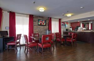 科珀斯克里斯蒂科珀斯克里斯蒂南红顶客栈的一间设有红色桌椅的餐厅和一间酒吧