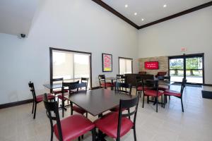 哈蒙德Red Roof Inn PLUS+ Hammond的用餐室配有桌子和红色椅子