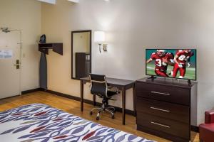 里士满Red Roof Inn Richmond, IN的酒店客房设有书桌和电视,还有一间客房。