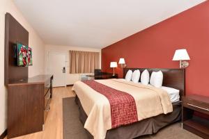 玛丽埃塔Red Roof Inn Marietta的一间卧室设有一张大床和红色的墙壁