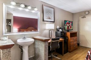 莫顿格罗夫Red Roof Inn Morton Grove的一间带水槽的浴室和一张带镜子的书桌