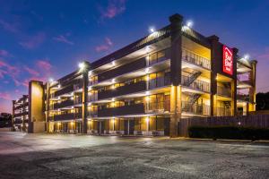 厄兰格Red Roof Inn Cincinnati Airport–Florence/ Erlanger的停车场内有 ⁇ 虹灯标志的大型建筑