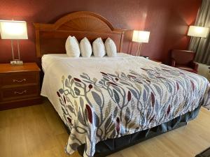 WheelersburgRed Roof Inn Portsmouth - Wheelersburg的酒店客房,配有一张带彩色床罩的床