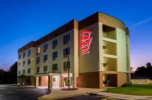 费耶特维尔Red Roof Inn & Suites Fayetteville-Fort Bragg的上面有 ⁇ 虹灯标志的酒店大楼