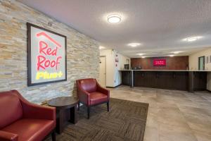 欧佩莱卡Red Roof Inn PLUS+ & Suites Opelika的一间设有两把椅子和红色屋顶围裙的等候室
