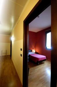 卡萨尔马焦雷艾尔伯格德莱尹杜斯特雷酒店的一间红色客房内的卧室