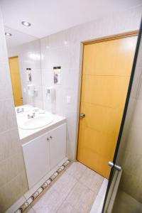 齐克拉约温梅尔赌场及酒店的一间带水槽和黄色门的浴室