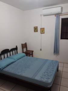 伊塔佩马Casa na praia 02的一间卧室配有一张带蓝色床单的床和风扇
